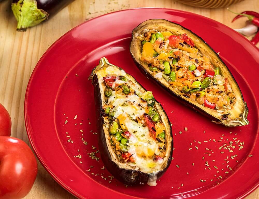 Beringela recheada com vegetais, com salada de tomate e oregãos